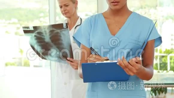 医生和她身后的同事在剪贴板上写字