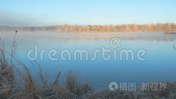在寒冷的早晨湖面上的晨雾