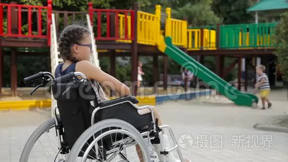 一个腿骨折的女孩坐在操场前的轮椅上短视频