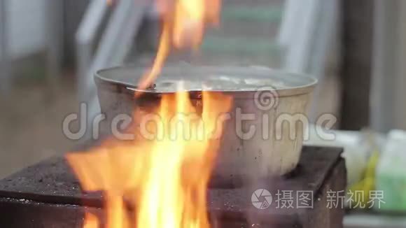 用明火烧柴炉上的金属锅煮鱼汤视频