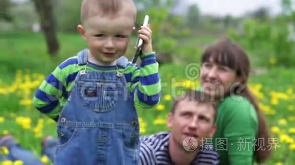 小男孩在春日草地上打电话视频