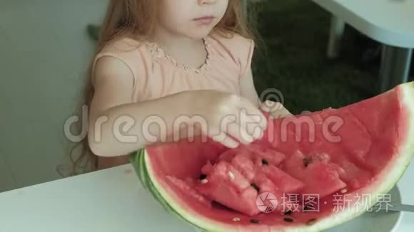 小女孩夏天在家厨房里吃西瓜