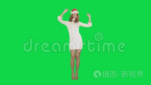 圣诞女孩戴着圣诞帽跳舞快乐地笑着