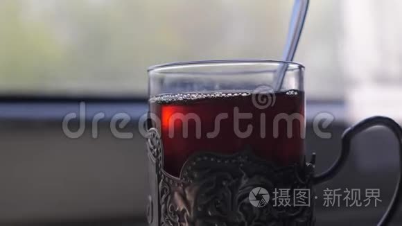 铁路旅行概念。 一杯杯子里有勺子的茶，老式的，站在一张桌子上，坐在火车的生活方式车厢里