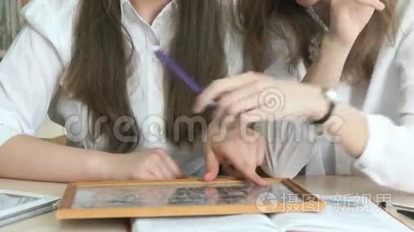 两个女学生带着照片看相框视频