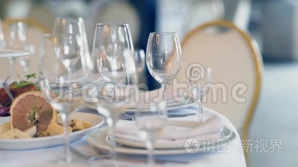 在餐厅的白色桌子上摆放健康食品和白色盘子和用具