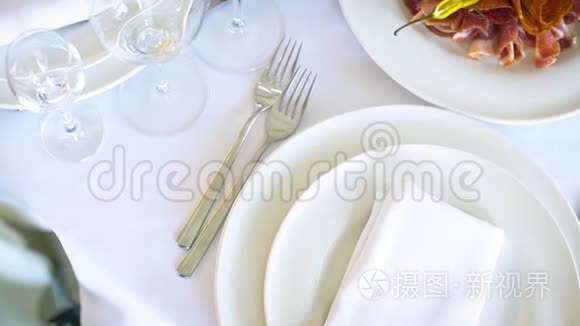 餐厅白色桌子上的白色盘子和用具