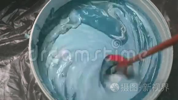 用专用喷嘴将桶钻中带有颜色色调的白色油漆混合的过程防止油漆。