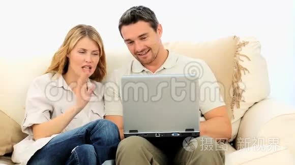 可爱的夫妇用笔记本电脑