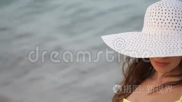 戴眼镜戴帽子的年轻女子在海边视频