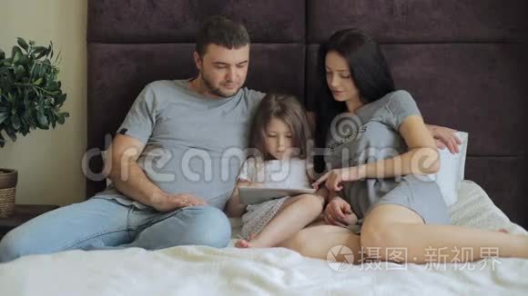 幸福的家庭躺在床上看着桌子视频