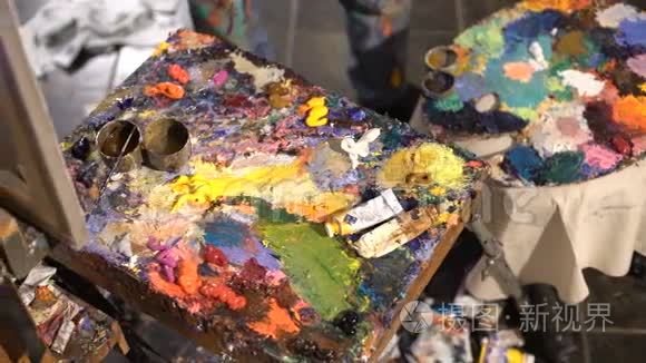 艺术家将各种颜色的油画颜料混合在托盘上