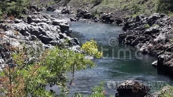 远离镜头的小河流在石岸间流动视频