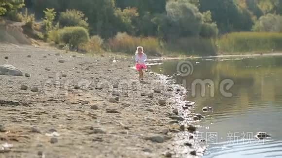 小可爱的女孩沿着湖边跑