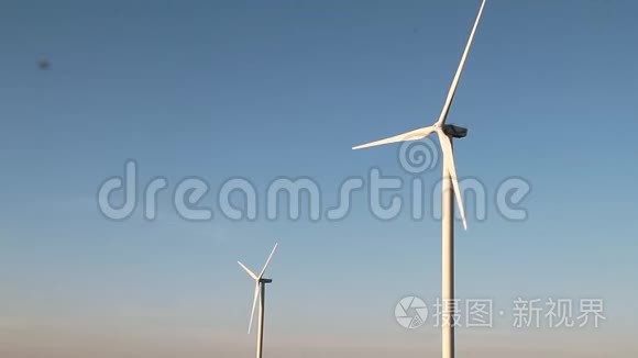 风力涡轮机在日落天空背景下，能源发电机自然友好。