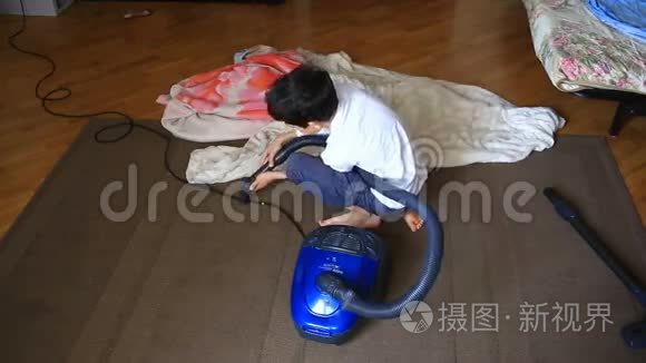 男孩用吸尘器打扫房间里的地毯视频