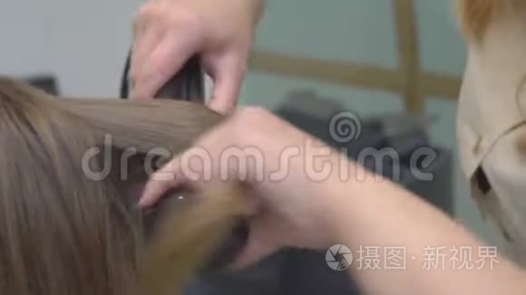 美发师在美女金发上做发型特写视频
