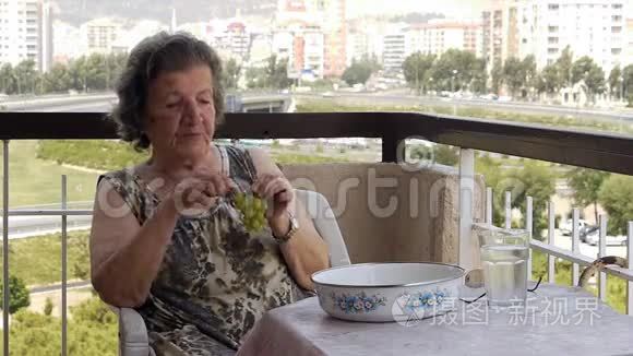 在阳台上吃葡萄的老退休妇女视频