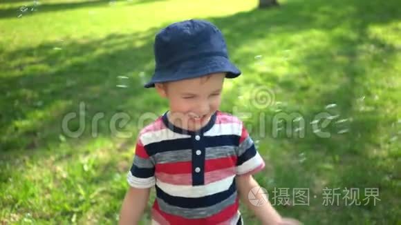 快乐的小男孩在公园里吹肥皂泡视频