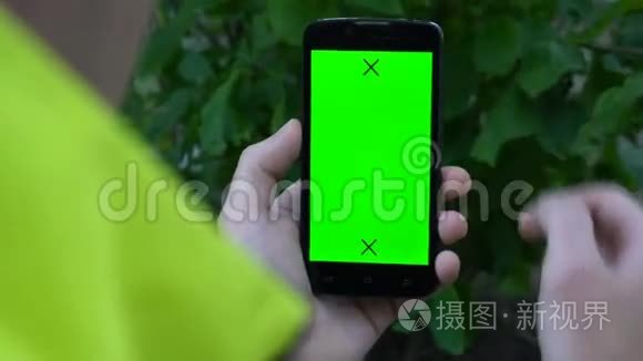 特写男性手握智能手机，带有绿色屏幕预设效果。