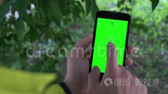 特写男性手握智能手机，带有绿色屏幕预设效果。