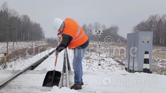工人用雪铲清理铁轨视频