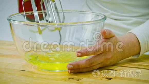 女人开始用手搅拌器做鸡蛋清视频