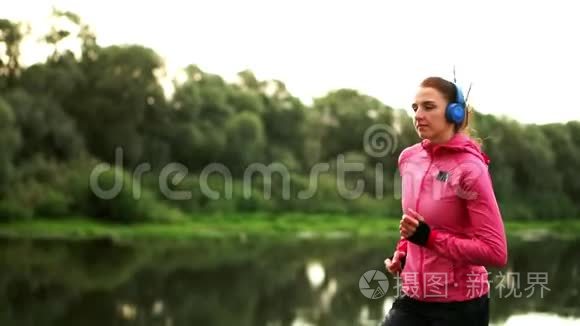 清晨在阳光明媚的黎明时分，在池塘附近的公园里慢跑，女孩正准备去马里亚诺，带领一个健康的人