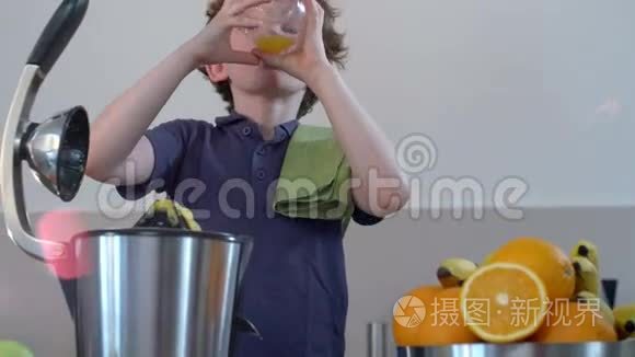 年轻有趣的白种人男孩在厨房用电榨汁机自制鲜橙果汁，然后饮用