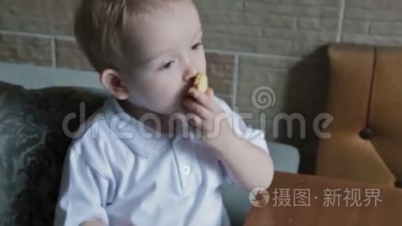 一个金发小男孩在厨房吃圆片视频