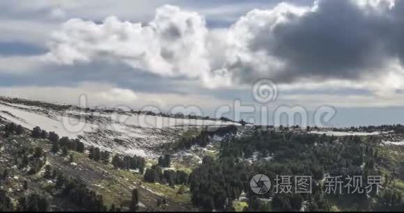 山顶后面云景的时间流逝。 雪，岩石，悬崖和深蓝色的天空。 高空。