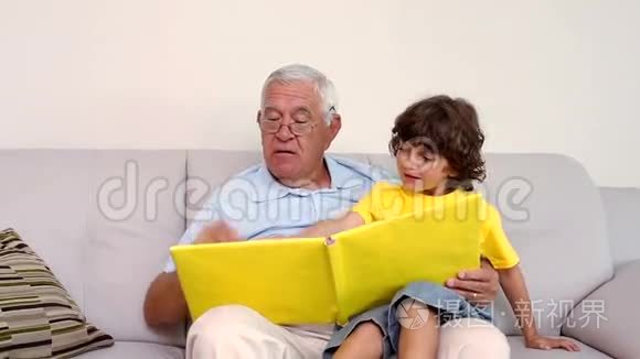 老人和孙子坐在沙发上看相册视频