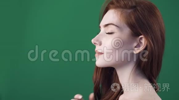 美丽的红头发女人在镜头上裸体的肩膀。