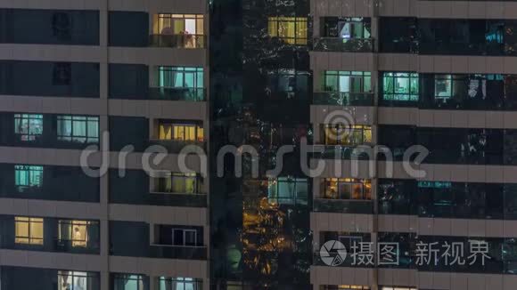 外部公寓楼时间推移夜景。 高耸的摩天大楼，窗户闪烁着灯光