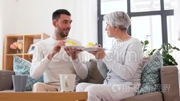 年长的母亲和成年的儿子在家吃蛋糕