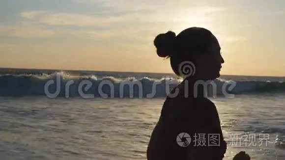 日落时在海边奔跑的年轻女子剪影。 日出时沿着海岸慢跑的女孩。 女性