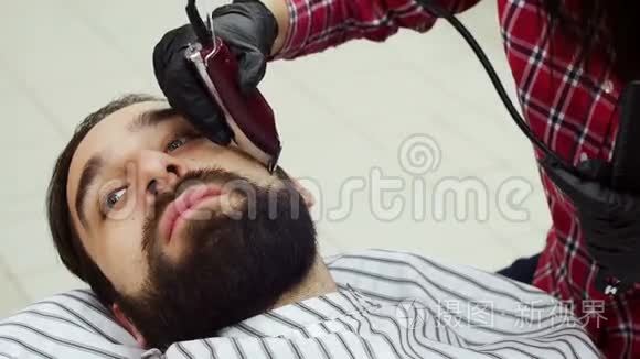 理发店的理发师用剪子修剪客户的胡须。