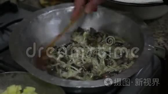 厨房。烹饪。准备食物的女人把土豆洋葱牛肉肾和肝放在锅里。