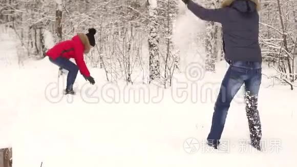 年轻夫妇在户外扔雪球。