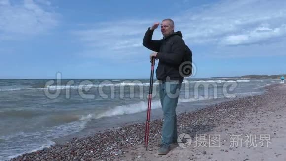 带着登山杖在海边的人视频