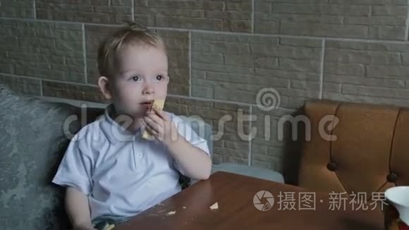 一个金发小男孩在厨房吃圆片视频
