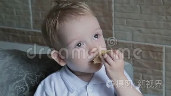 一个金发小男孩在厨房吃圆片