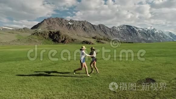 时髦的嬉皮士女孩在户外玩得很开心。 三个可爱的女人在绿草上旋转。 最好的朋友。