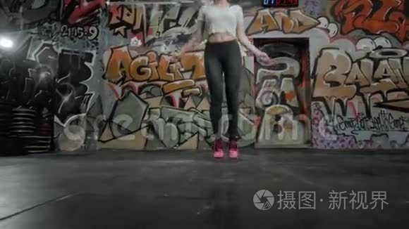 美丽的运动女性在交叉健身馆用跳绳锻炼，女孩运动员跳跃