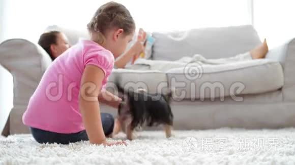 小女孩在沙发上和妈妈一起玩小狗和骨头