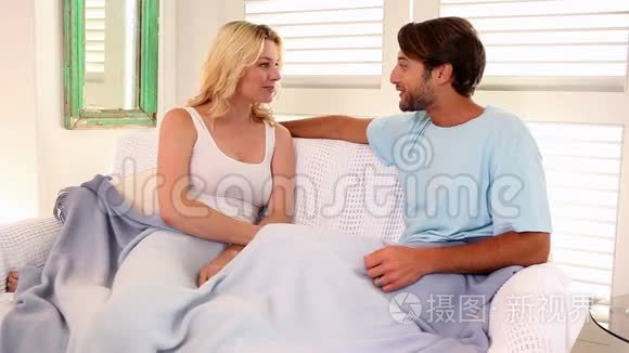 深情的一对夫妇坐在沙发上铺着毯子