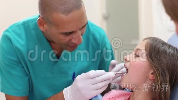 关闭牙科助理检查小女孩的牙齿视频