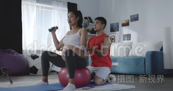 年轻男子在锻炼中指导孕妇视频