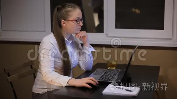 疲惫的商务女性戴着眼镜，深夜在办公室笔记本电脑里工作。 在深夜学习。 熬夜