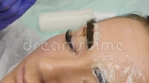 大师的特写双手做眉毛纹身。 永久性眉妆